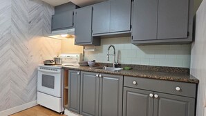 A compact kitchen with grey cabinets, a white stove, and a granite countertop. - Home sweet Home (Surrey)