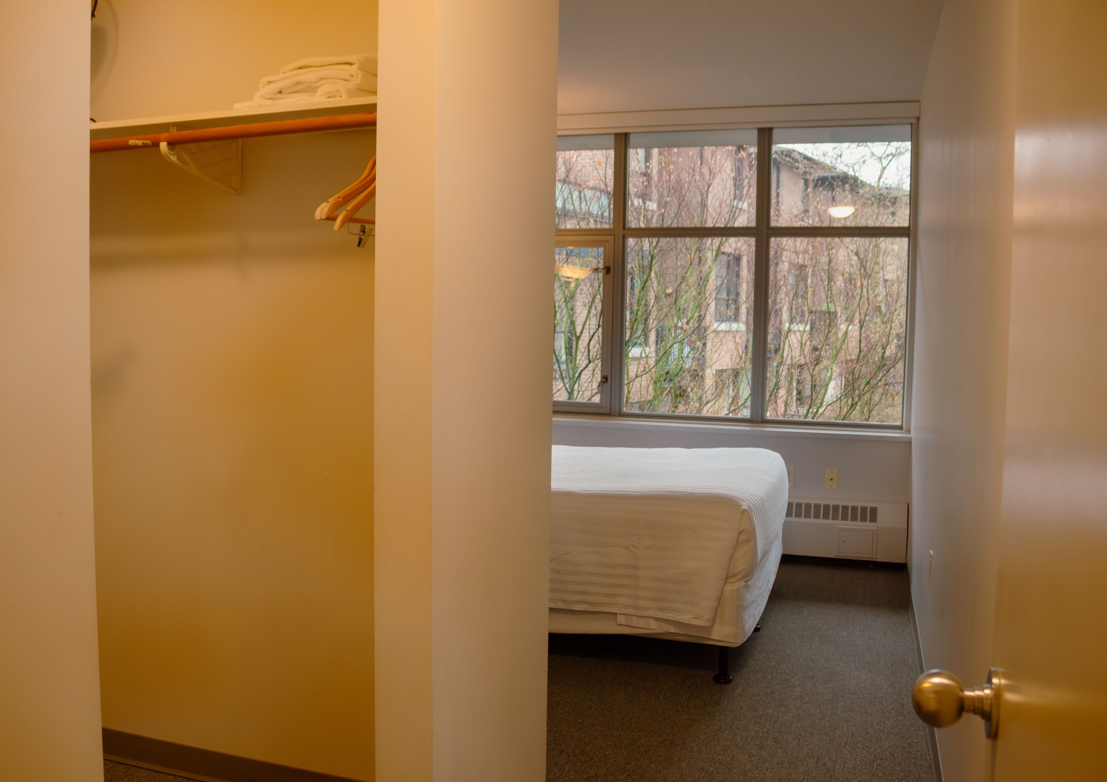 A bedroom with a bed, a window, and a radiator.