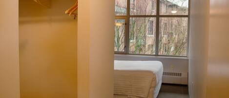 A bedroom with a bed, a window, and a radiator.