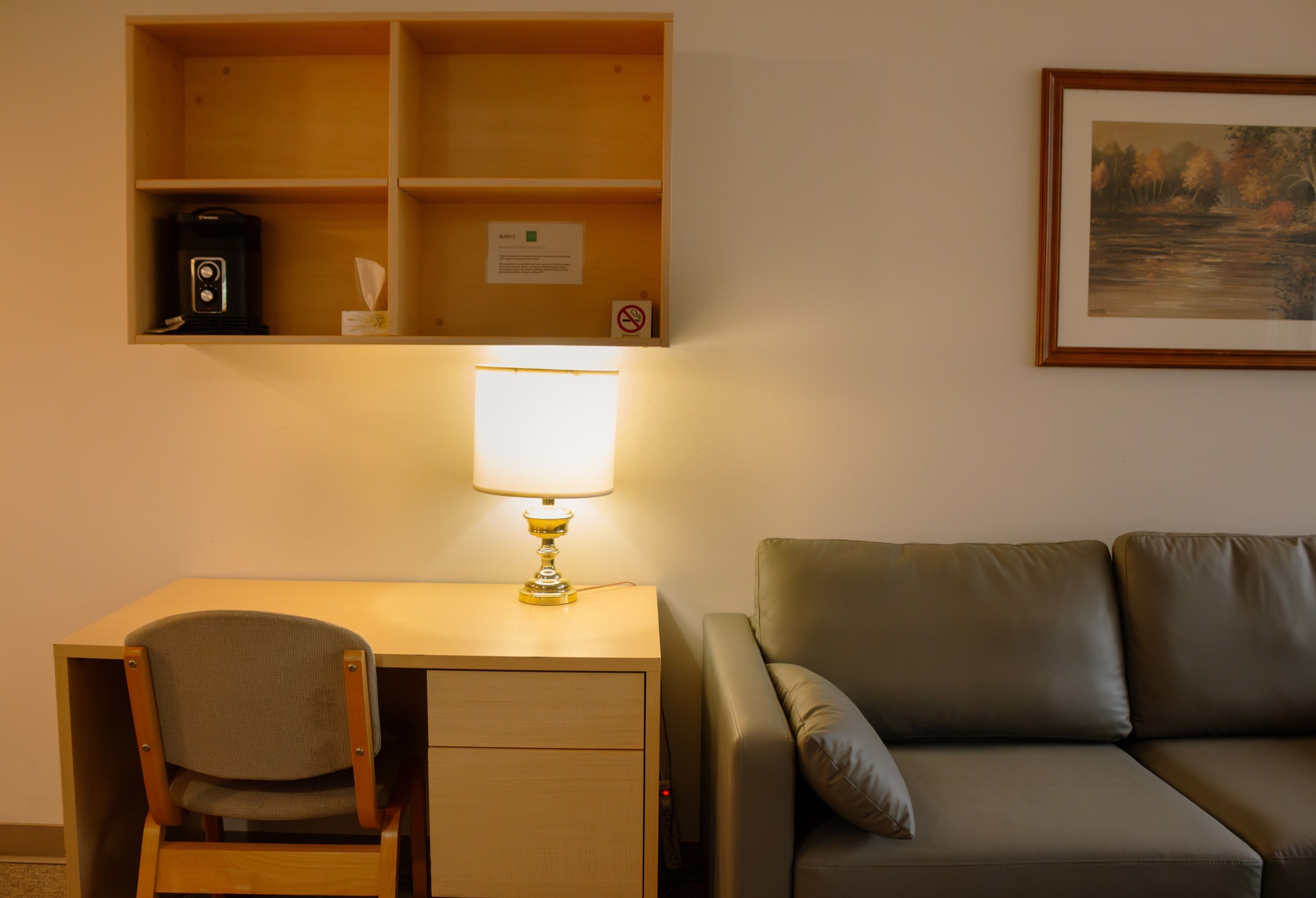 A room with a desk, chair, and a couch.