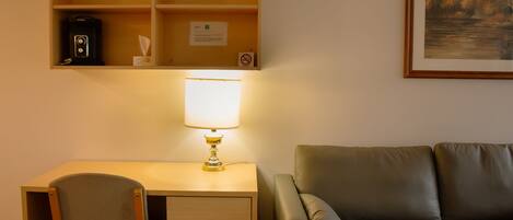 A room with a desk, chair, and a couch.