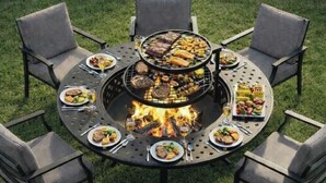 A round outdoor dining table with a built-in grill, surrounded by four chairs. - Casa encanto, your home away from home. (Lehigh Acres)