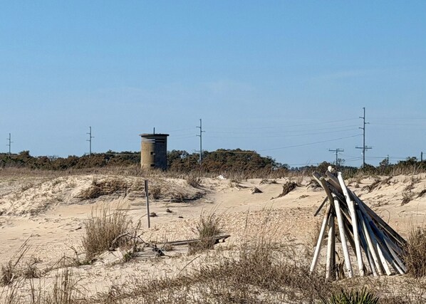 Un paysage sablonneux avec une structure en béton et des planches de bois.