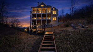 A multi-story house with a wooden staircase leading to a porch. - Lake Views, Gym & Arcade | Gated | Sleeps 9 (Sevierville)