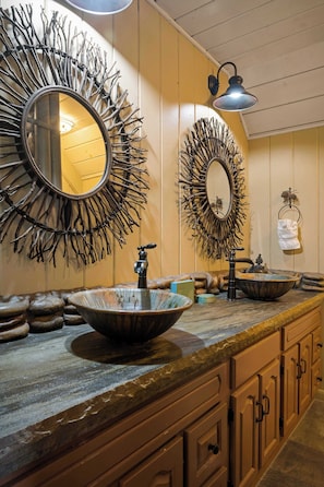 Un bagno con uno specchio grande, un lavabo e un porta asciugamani.