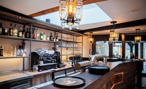 A bar area with shelves of liquor bottles, a coffee machine, and a counter with a coffee pot.
