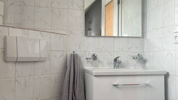 Un bagno moderno con il water, un lavandino, uno specchio e un portasciugamani.
