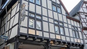 Een traditioneel vakwerkhuis met een bord waarop ‘Wolfschlucht’ staat.