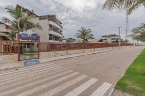 Una entrada cerrada a un resort frente al mar, con una rampa accesible para sillas de ruedas y un letrero con el nombre.