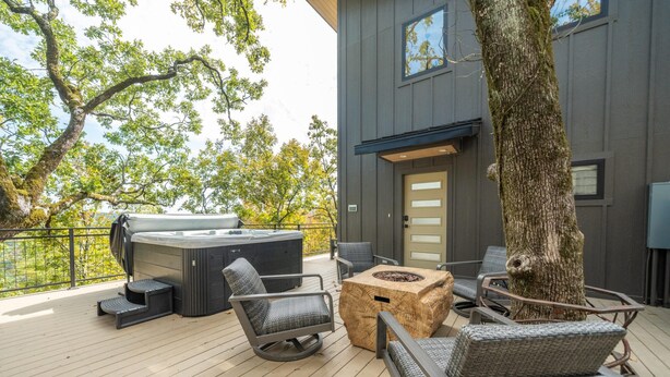 A deck with outdoor furniture, a hot tub, and a fire pit. - The Sun at In the Trees Luxury Resort🌳, Mountaintop, Hot Tub, Fireplace, Full Kitchen (Hot Springs National Park)