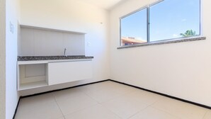 A room with a kitchen counter, a window, and a tiled floor. - Exclusive Duplex at Beach Townhouse IV by Carpediem (Aquiraz)