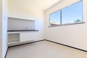 A room with a kitchen counter, a window, and a tiled floor. - Exclusive Duplex at Beach Townhouse IV by Carpediem (Aquiraz)