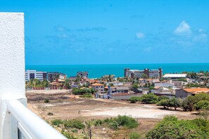 A coastal town with buildings, a clear blue sky, and the sea in the background. - Exclusive Duplex at Beach Townhouse IV by Carpediem (Aquiraz)
