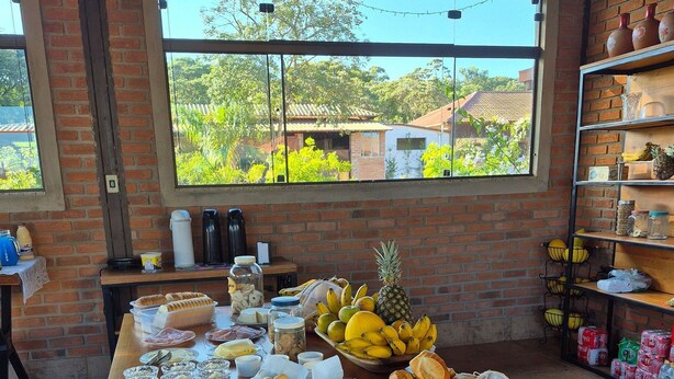 A breakfast buffet with various food items and a view of greenery outside.