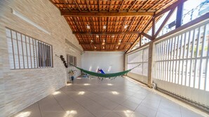 Un vaste espace intérieur doté d’un haut plafond, de grandes fenêtres et d’un hamac.