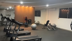 Un gimnasio con cintas de correr, pelotas de ejercicio y máquinas de pesas.