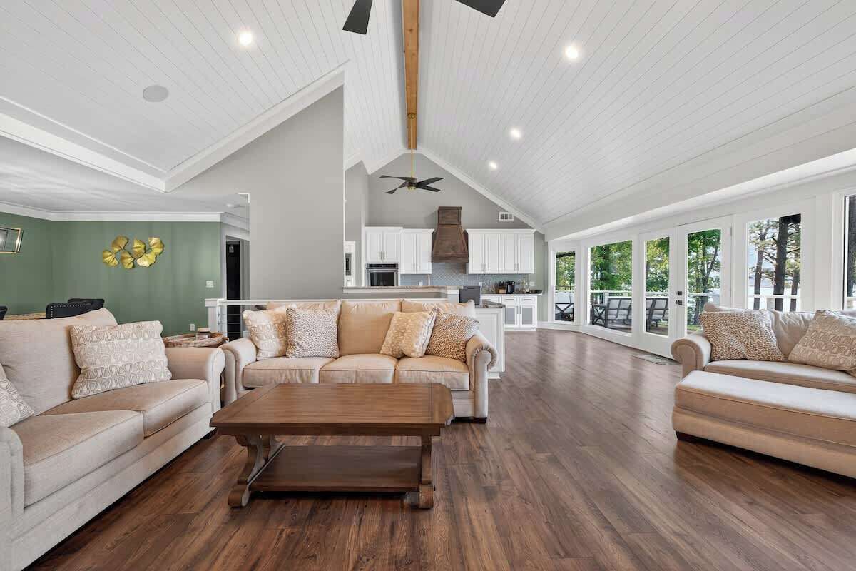 A spacious living area with a high ceiling, a dining area, and a kitchen.