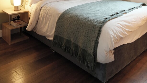 A bedroom with a bed, nightstand, and a window with curtains. - Cozy apartment in the heart of Marylebone. 5 min walk to Baker Street Station! (London)