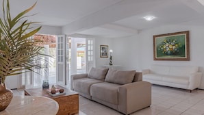 Ein Wohnzimmer mit einem beigen Sofa, einem Couchtisch und einer Topfpflanze.