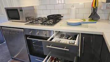 A modern kitchen with a microwave, gas stove, oven, and stainless steel dishwasher.