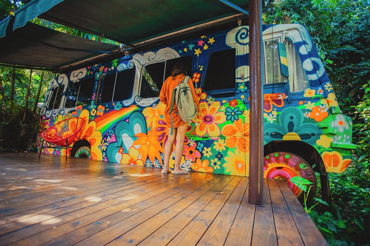 Ein farbenfroher Bus mit floralen und abstrakten Mustern auf einem Holzboden geparkt.