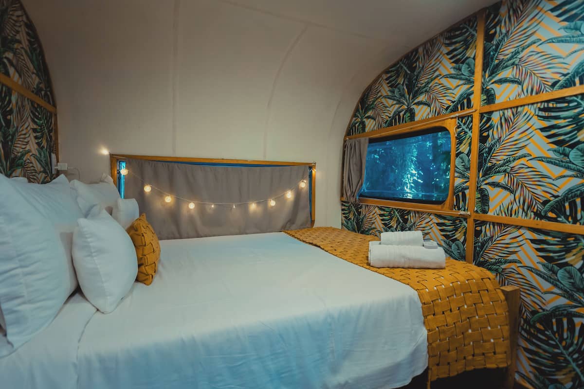 Ein Schlafzimmer mit Bett, Nachttisch und einem Fenster mit Blick.