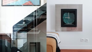 A modern interior with a staircase, a clock, and a bed. - Écrin d’architecte sous verrière • Marais (Paris)