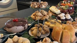 Un bufé con diversos postres, incluyendo pasteles, repostería y fruta.