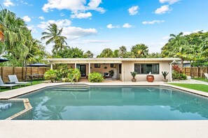 Ein Wohnobjekt mit Pool, Außenbereich und tropischer Bepflanzung.