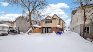 A residential street with houses, parked cars, and snow-covered ground. - Cozy & practical apartment in Hull 5 min to Ottawa (Gatineau)