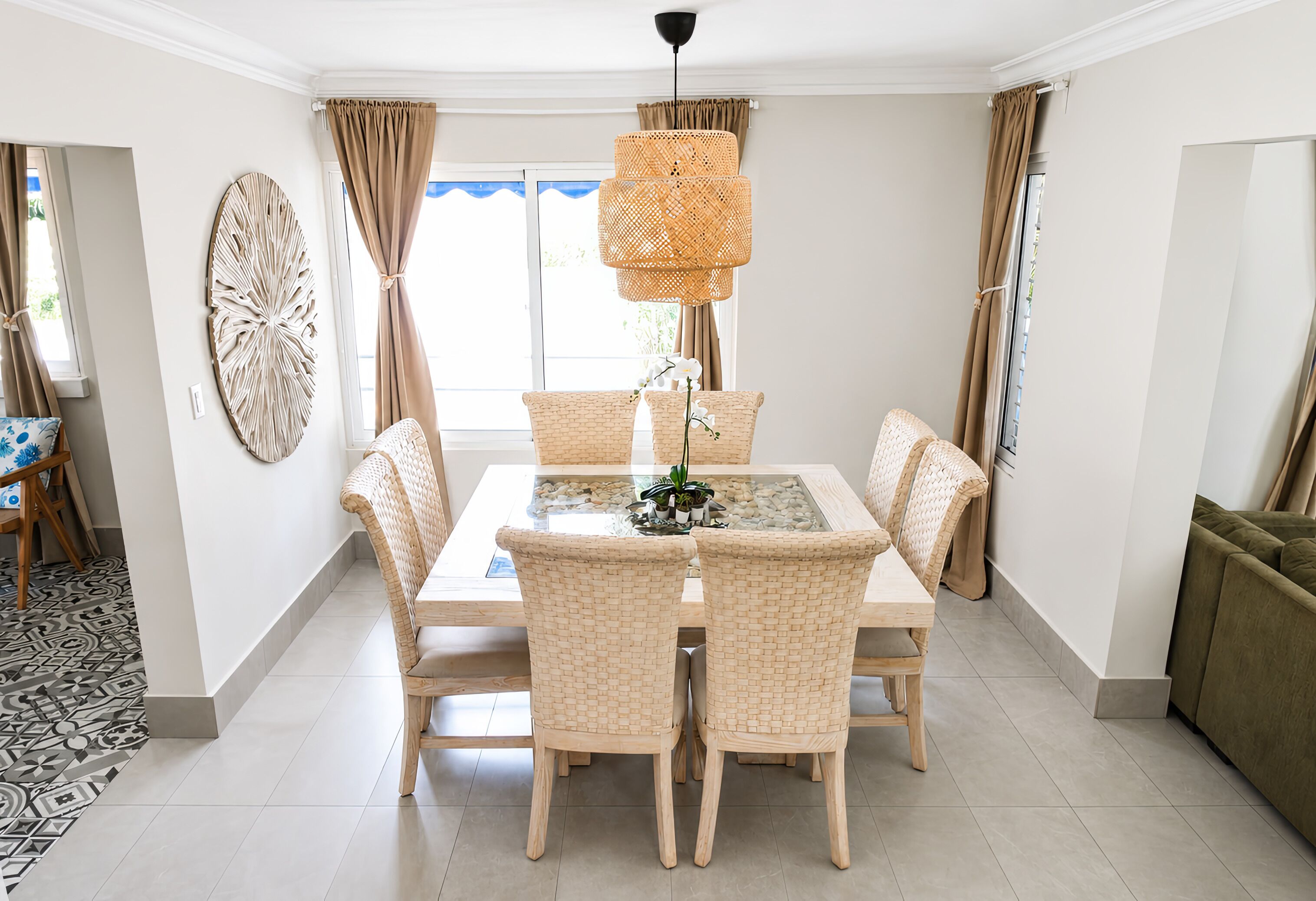 A dining area with a table, chairs, and a hanging light fixture.