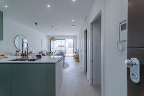 A modern kitchen with a central island, a dining area with a table and chairs, and a view to the outside. - Escape to LA Paz - sun, peace and luxury awaits you! 🌞 (Los Alcázares)