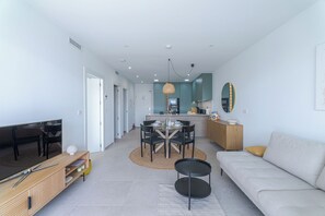 A modern living room with a sofa, dining table, and kitchen area. - Escape to LA Paz - sun, peace and luxury awaits you! 🌞 (Los Alcázares)