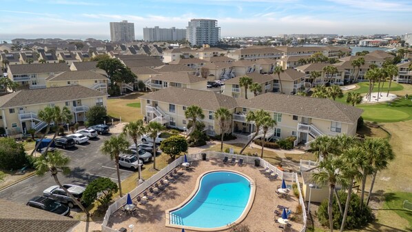 A resort with a swimming pool, multiple buildings, and a view of the ocean. - FREE Beach Service • Private Beach • 5 Pools • Restaurant • pitch and putt golf (Destin)