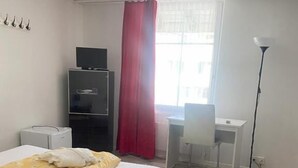 A hotel room with a bed, a desk, a chair, a TV, and a lamp. - Gasthof Sternen Thörishaus (Neuenegg)