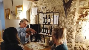 Un interior rústico con pared de piedra, botellero y suelo estampado.