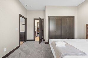 Ein Schlafzimmer mit einem Bett, einem Kleiderschrank und einer offenen Tür zu einem Flur.