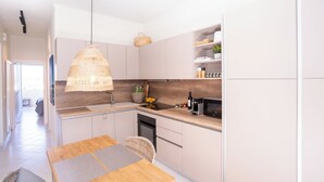 A modern kitchen with a wooden countertop, a hanging light fixture, and a built-in oven. - Design-Apartment mit 2 Balkonen & gehobener Ausstattung (Rodos)