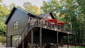 Eine moderne Hütte mit überdachter Terrasse und Sitzbereich im Freien.