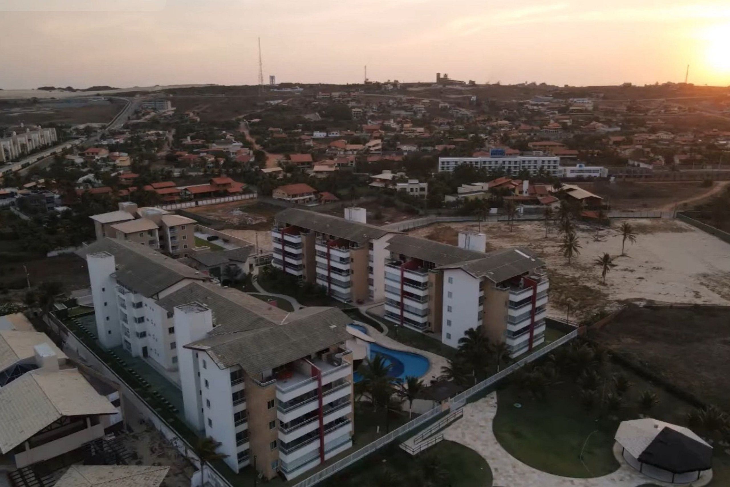 Zona residencial con edificios de varios pisos, una piscina y una playa.
