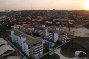 Un quartier résidentiel avec des immeubles à plusieurs étages, une piscine et une plage.