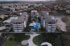 Un hotel de gran altura con piscina central y varios balcones.