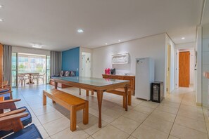 Une cuisine moderne avec une table à manger au plateau en verre, des bancs en bois et un four encastré.