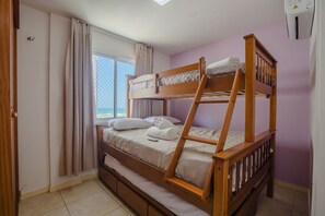 A bunk bed room with a window, curtains, and a thermostat on the wall. - Costa Blanca #304 - Beachfront Apto by Carpediem (Aquiraz)