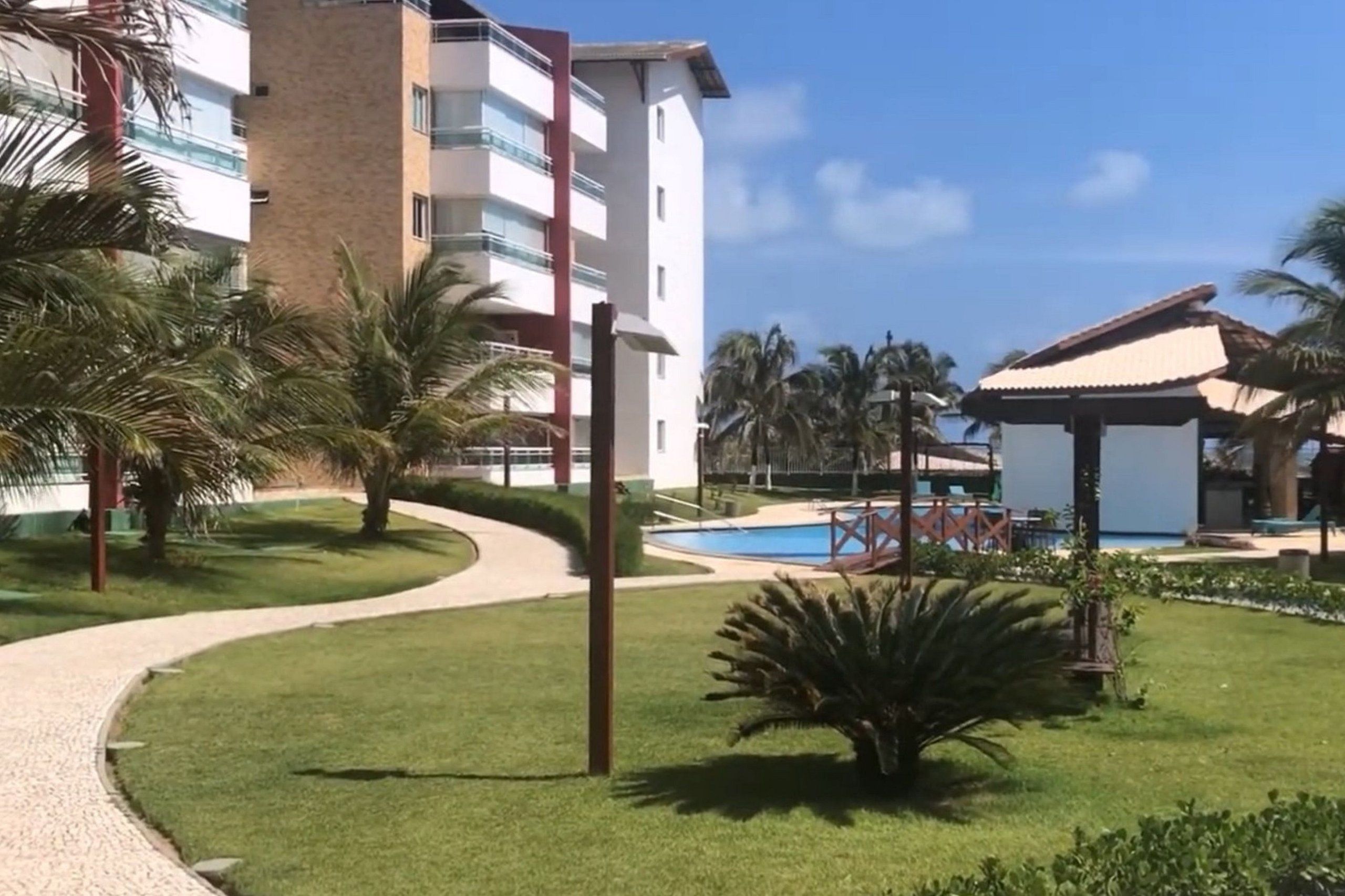 Ein Resort mit Pool, Palmen und einem Gebäude mit Balkonen.