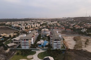 Un quartier résidentiel comprenant plusieurs immeubles d’appartements, une piscine et une plage.