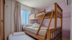 A bunk bed room with a window, curtains, and a door. - Costa Blanca #304 - Beachfront Apto by Carpediem (Aquiraz)
