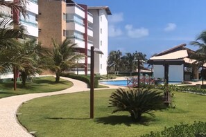 Ein Resort mit Pool, Palmen und einem Gebäude mit Balkonen.