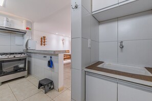 Een moderne keuken met witte kasten, een inbouwoven en een aanrecht.