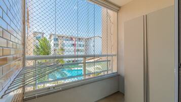 Un balcón con vista a una piscina y edificios.